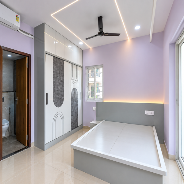 Modern bedroom, luxury bedroom, contemporary bedroom design, elegant bedroom, spacious bedroom, pastel wall color, lavender bedroom, modern bed frame, upholstered headboard, built-in wardrobe, designer wardrobe, white wardrobe doors, geometric wardrobe design, LED ceiling lighting, false ceiling, ceiling fan, glossy floor tiles, large windows, natural light, premium apartment, stylish bedroom, sophisticated interior, minimalist bedroom, luxury home interior, modern Indian bedroom, spacious sleeping area, contemporary furniture, warm ambient lighting, clean interior, premium residential design, elegant home, modern wardrobe, built-in storage, decorative wall lighting, polished flooring, bright bedroom, upscale apartment, luxury property, beautiful bedroom, designer interior, modern architecture, comfortable bedroom, refined decor, stylish home design, contemporary living, premium interiors, high-end residence, modern lifestyle, elegant residential property, luxury bedroom interior.